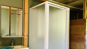A bathroom with a white sink, a mirror, and a frosted glass shower enclosure. - LITTLE QUIET CORNER FOR NATURE LOVERS ... (Olivese)
