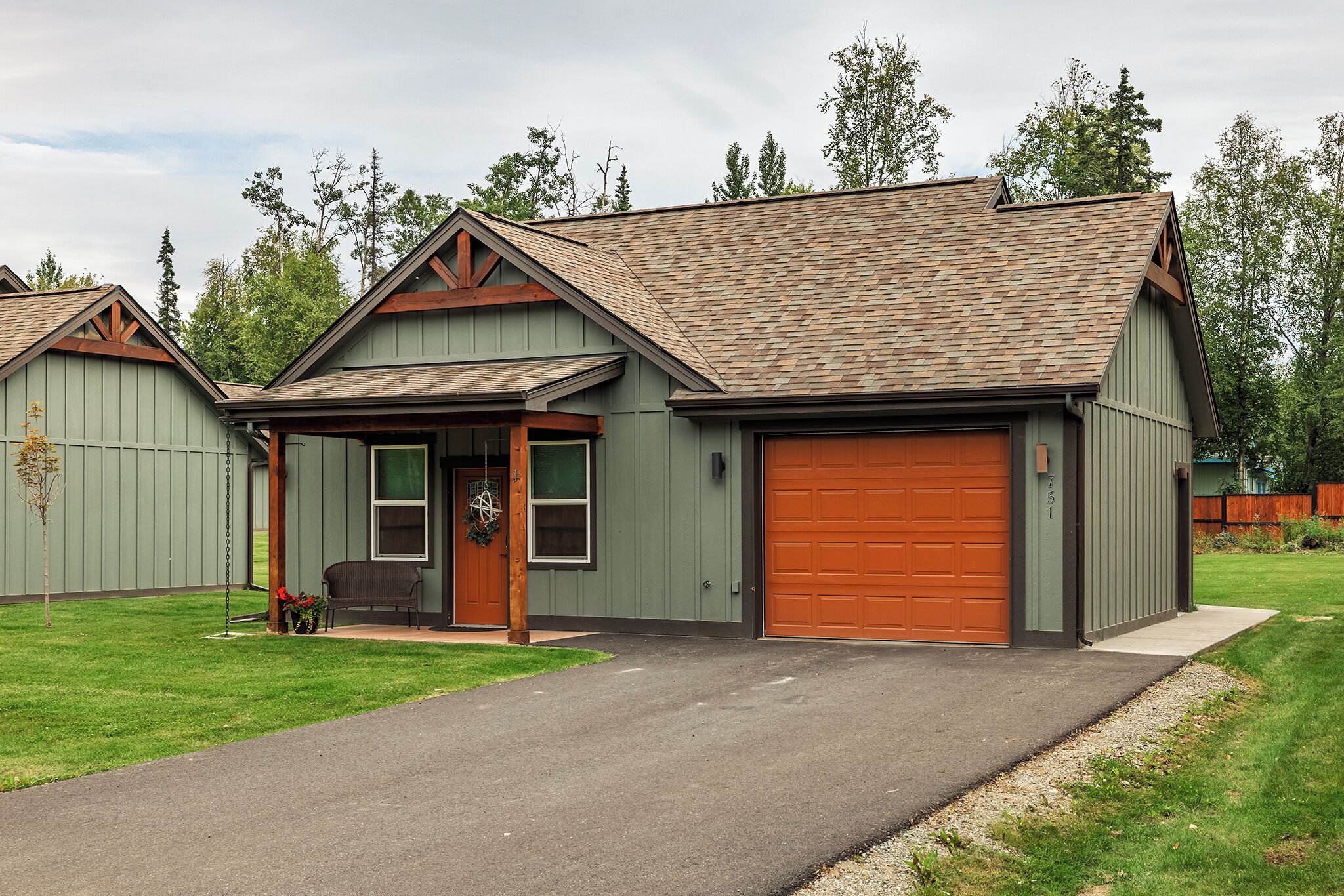 A single-story house with a garage, a covered porch, and a well-maintained lawn.