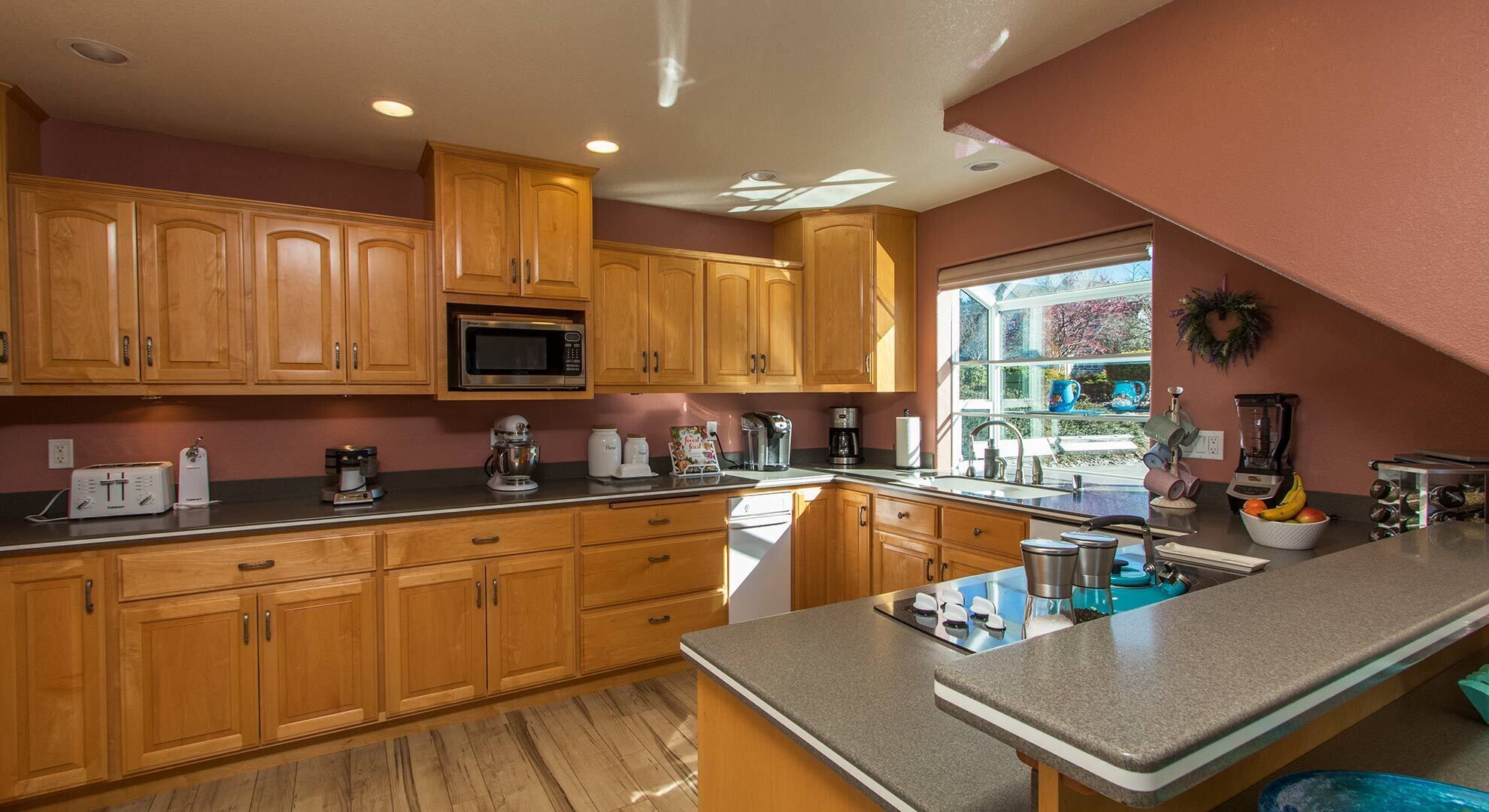 A kitchen with wooden cabinets, a microwave, a coffee maker, and a blender.
