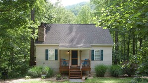 A house with a porch, two chairs, and a small garden. - Couples Mountain Retreat (Montebello)