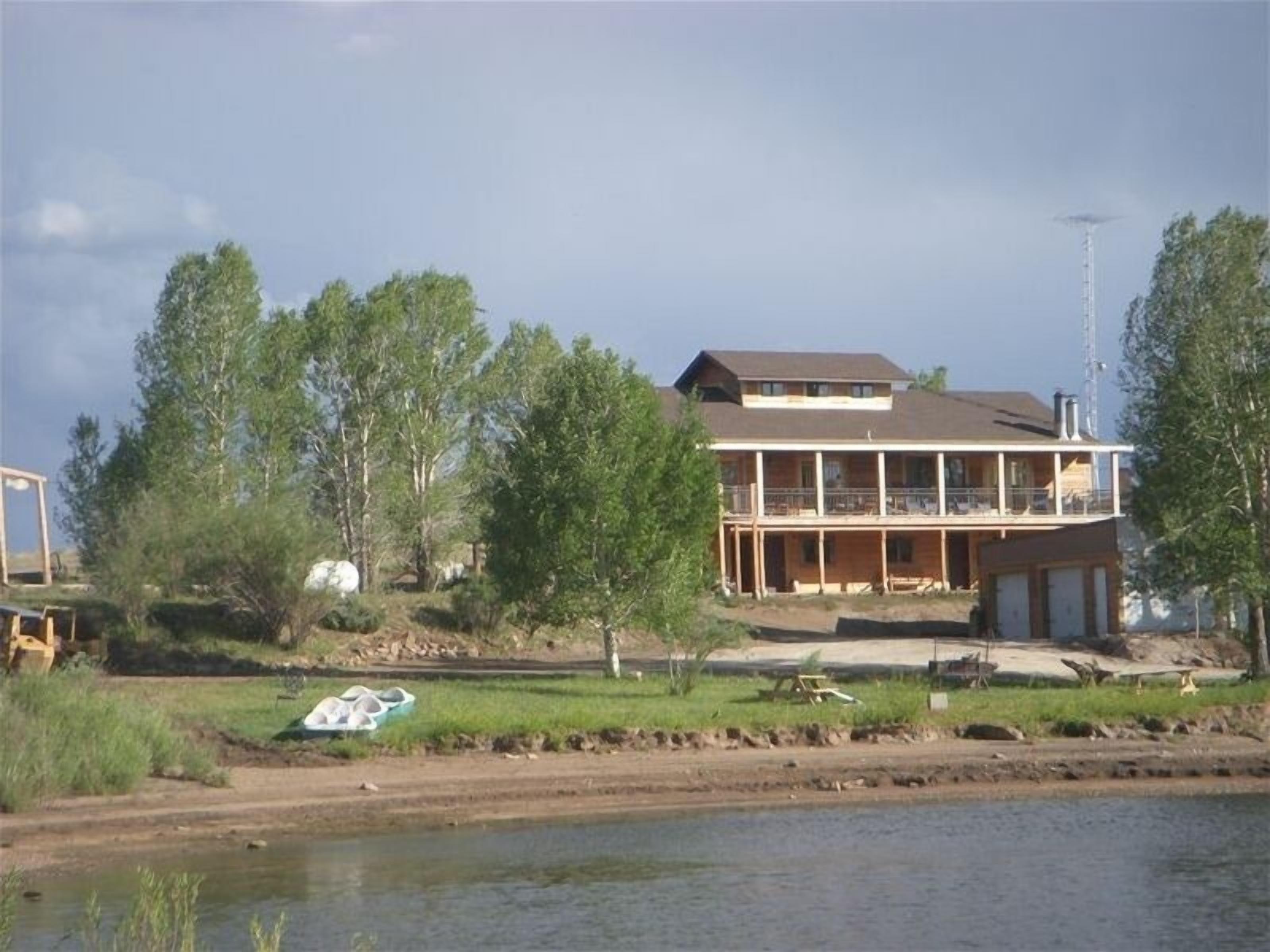 A two-story building with a balcony, located near a body of water.