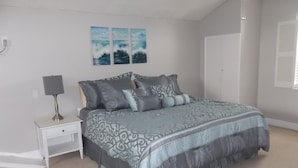 A bedroom with a bed, nightstand, lamp, and wall art. - Quiet Culdesac, Golf Course view, 3 Bedroom 2 Bath, Sleeps 8! (Marco Island)