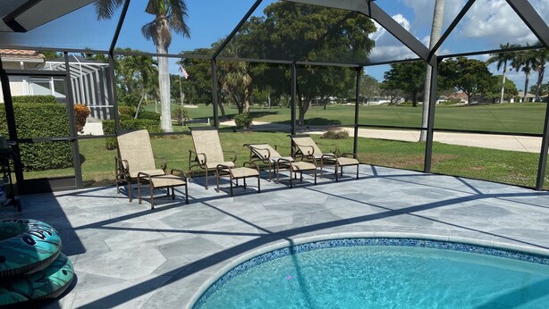 A swimming pool with lounge chairs and a covered patio area. - Quiet Culdesac, Golf Course view, 3 Bedroom 2 Bath, Sleeps 8! (Marco Island)