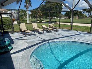 A swimming pool with lounge chairs and a covered patio area. - Quiet Culdesac, Golf Course view, 3 Bedroom 2 Bath, Sleeps 8! (Marco Island)