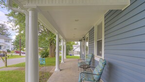 A covered porch with two chairs and a table, white columns, and a blue house in the background. -  8 Min. to VT,  15 min. to RU & 4 min. to AQUATIC CENTER  (Christiansburg)