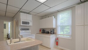 A kitchen with white cabinets, a microwave, a stove, a sink, and a window with blinds. -  8 Min. to VT,  15 min. to RU & 4 min. to AQUATIC CENTER  (Christiansburg)