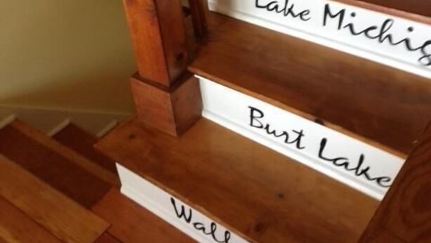 A wooden staircase with steps labeled with names of lakes. - 
VENETIAN'27SEND INQUIRY! Walk to Everything/Fenced Yard/Enclosed Front Porch/AC (Charlevoix)
