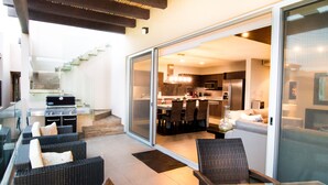 Un espacio habitable de concepto abierto con cocina, comedor y una escalera que lleva a un nivel superior.