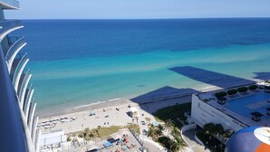 A beach view from a high vantage point, including a pool area with lounge chairs and umbrellas, and a clear view of the ocean. - LYFE RESORT,  OCEANFRONT BDG.  ROOFTOP POOL & RESTAURANT, WATER VIEWS GUARANTEED (Hollywood)