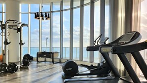 A modern gym with treadmills, weight machines, and a rowing machine. - LYFE RESORT,  OCEANFRONT BDG.  ROOFTOP POOL & RESTAURANT, WATER VIEWS GUARANTEED (Hollywood)