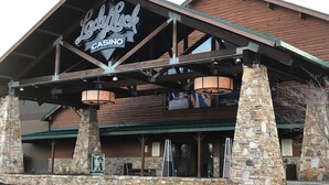 A casino with a prominent sign, stone pillars, and a wooden facade.