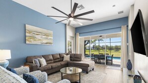 A living room with a sectional sofa, a round coffee table, and a ceiling fan. - Welcome to The Windsor Magic with Professional Arcade Room! Brand New 2024! (Kissimmee)