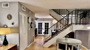 Un vaste espace de vie comprenant un escalier, une table à manger et une lampe.