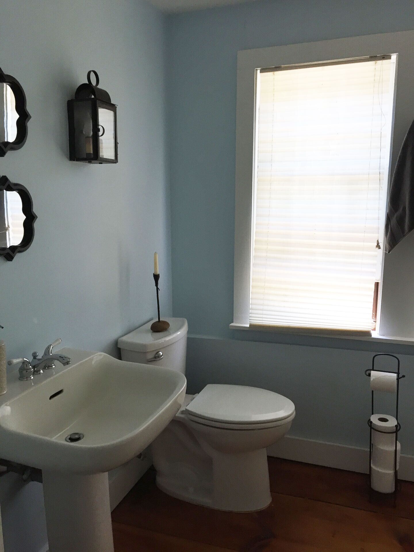 A bathroom with a sink, toilet, and window.