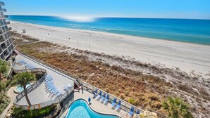 A resort with a pool, beach, and ocean view.