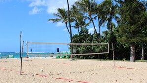 A beach volleyball net on a sandy court with a view of the ocean and palm trees in the background. - Surfer's Dream Condo w/ Full Kitchen - Free Wifi, Sleeps 4 (Honolulu)
