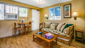A living room with a sofa, two chairs, a coffee table, and a lamp. - Surfer's Dream Condo w/ Full Kitchen - Free Wifi, Sleeps 4 (Honolulu)