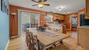 Une cuisine spacieuse dotée d’un îlot central, de meubles en bois et d’un coin repas avec une grande table et des chaises.