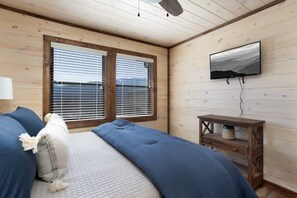A bedroom with a bed, a TV mounted on the wall, and a window with blinds. - Unreal Views GSMNP/Near DwTn Gatlinburg/Hot Tub (Gatlinburg)