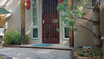 Un edificio con entrada de piedra, puerta de madera y un pequeño porche.