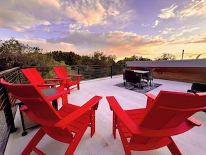 A rooftop patio with red Adirondack chairs, a table, and a view of the sunset. - Tiny Home near Zion with Rooftop Stargazing Deck (Orderville)