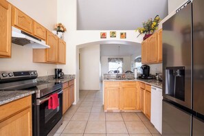 A modern kitchen with wooden cabinets, stainless steel appliances, and a central island.