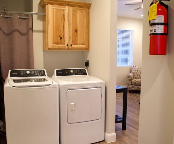 A laundry area with two front-loading washers and a wooden cabinet above.