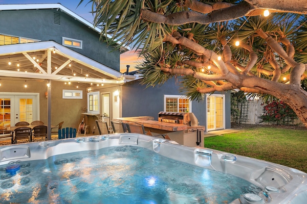 Our beautifully lit backyard, including a clean and spacious jacuzzi.