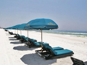 A row of beach umbrellas and lounge chairs on a sandy beach. - Luxuriously Furnished 3Bd Condo 2 Ocean Front Balconies with Breathtaking Views (Panama City Beach)