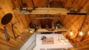 A rustic wooden interior with exposed beams, a wooden ceiling, and hanging light fixtures. - Cozy A-Frame house in heart of the midwest!!! (Quincy)