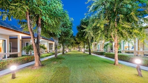 A well-maintained courtyard with evenly spaced trees and a tiled walkway.