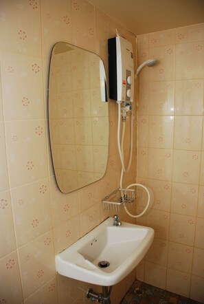 A bathroom with a sink, mirror, and shower. - Baan Kum Siri (Hua Hin)
