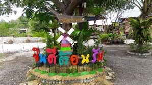 Uma área de jardim com uma placa de boas-vindas, um moinho de vento e letras coloridas formando a palavra 'welcome'.