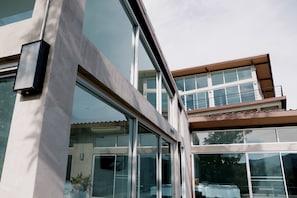 A modern building with large glass windows and a balcony.