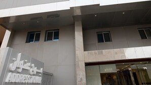 Un bâtiment moderne doté d’un espace d’accueil, de nombreuses fenêtres et d’une enseigne indiquant qu’il s’agit d’un immeuble de bureaux.