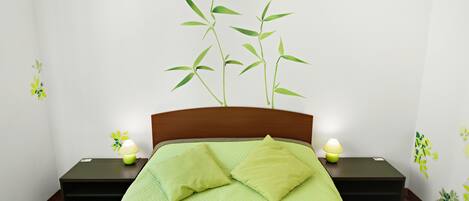 Una cama bien hecha con colcha y almohadas verdes, dos mesitas de noche con lámparas y una pared con un adhesivo de planta de bambú.