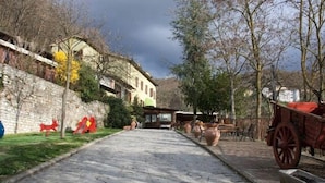 A stone-paved pathway leading to a rustic building with a stone wall on one side and a wooden fence on the other. - Agriturismo Le Francesche (Nocera Umbra)