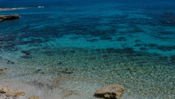 A clear view of a rocky shoreline with calm blue waters. - Guest House  steps from ocean... (Chersonissos)