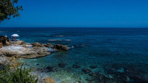 Una playa cerca, sillas reclinables de playa, toallas de playa