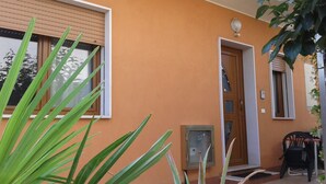 A building with a beige exterior, a wooden door, and a window with blinds. - "Like at home" near Venice. (Venezia)