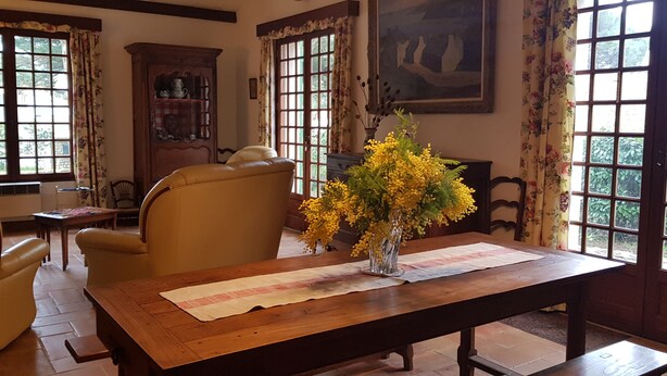 A dining area with a wooden table, chairs, and a vase of yellow flowers. - House / Villa - RIVEDOUX  PLAGE (Rivedoux-Plage)