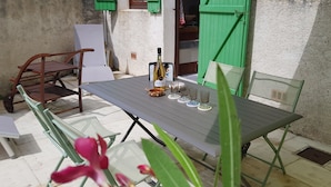 A table set outdoors with a bottle and glasses, surrounded by chairs and plants. - House / Villa - RIVEDOUX  PLAGE (Rivedoux-Plage)