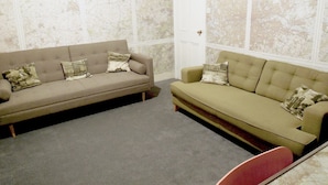 A room with two sofas and a door.