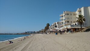 Een strand met gebouwen, palmbomen en een heldere lucht.