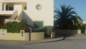 Un edificio moderno con techo plano, ventanal circular y un pequeño balcón.
