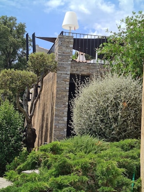 Set amidst lush vegetation, this structure features a stone facade and metal railing.