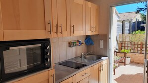 Een moderne keuken met houten kastjes, een inbouwoven en een spoelbak.
