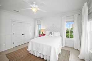 A bedroom with a bed, white curtains, a ceiling fan, and a window with a view. - Magazine Gorgeous Orange Beach Oasis - 5 BR, Family, Bikes, Beach, Relax (Orange Beach)