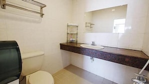 A bathroom with a toilet, sink, and mirror. - Formost Hotel (Hengchun)
