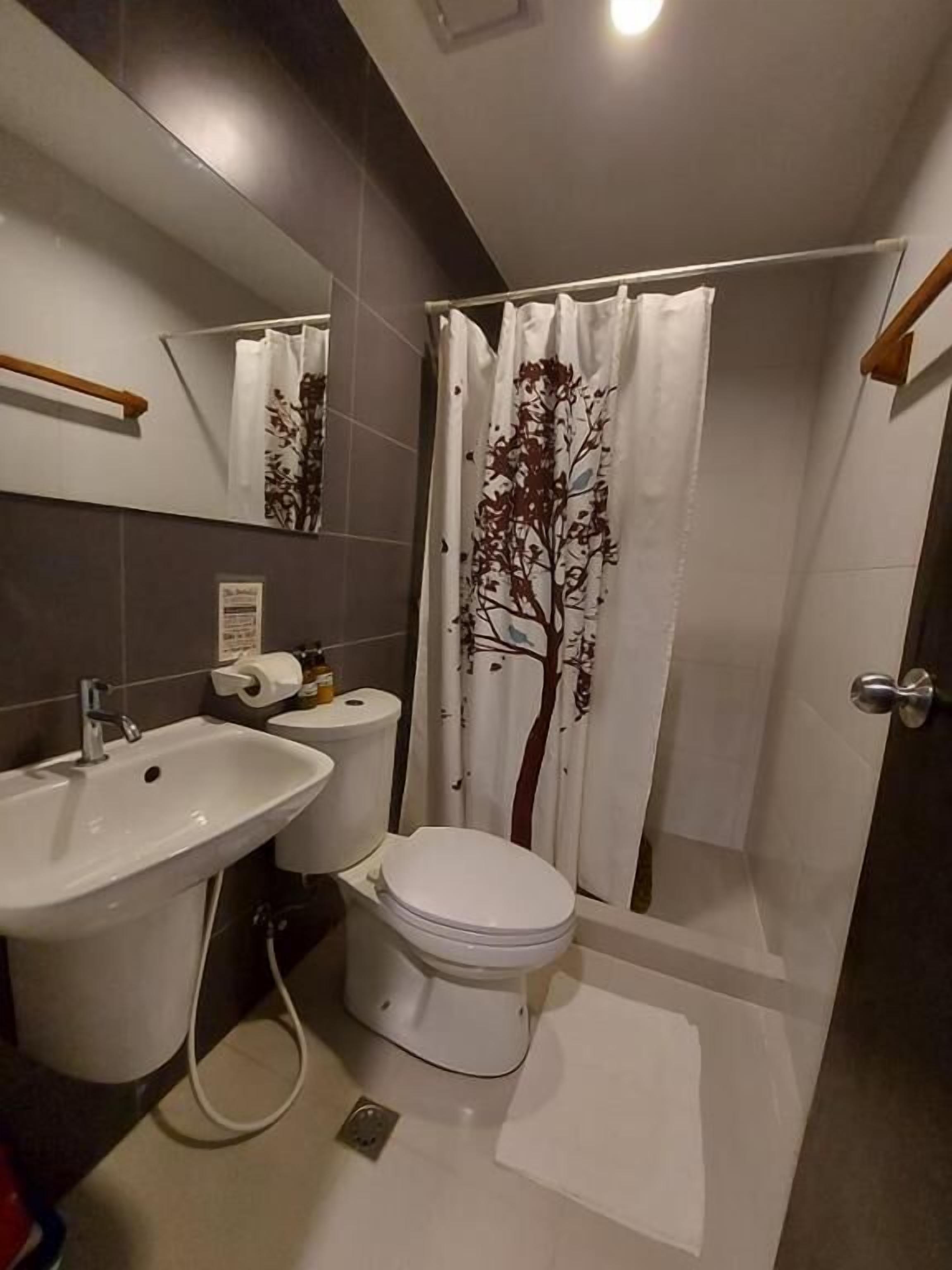 Een badkamer met een wastafel, toilet en douchegordijn.